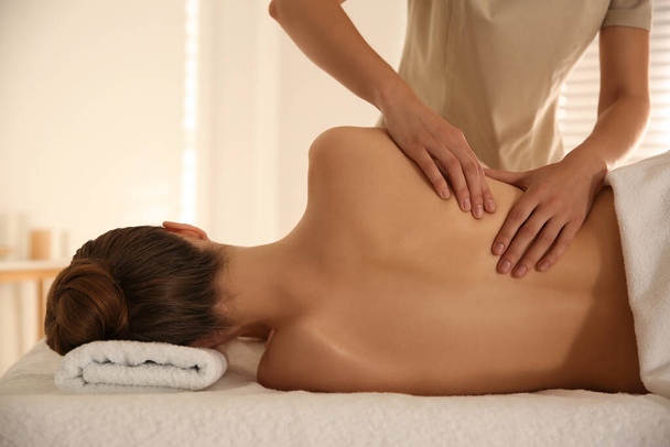 Young woman receiving back massage in spa salon - Фото, зображення