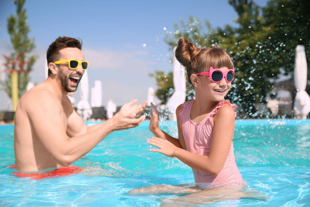 Father and daughter having fun in swimming pool. Family vacation - Fotoğraf, Görsel