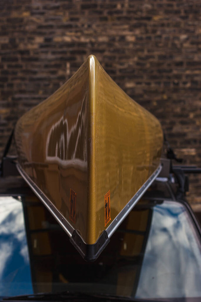 Каноэ на вершине автомобиля перед кирпичной стеной - Фото, изображение