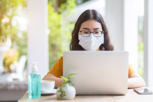 freelance people business female wearing protective mask casual working with laptop computer in coffee shop like the background,working from home,Concept of Prevention of the spread of COVID-19 virus - Foto, Imagem