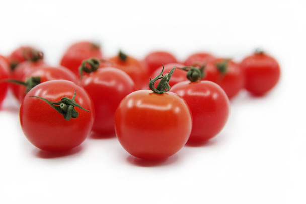 Tomates cherry aislados sobre un fondo blanco. Tomates rojos en una ramita - Foto, Imagen