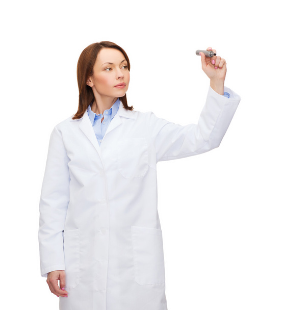 Young female doctor writing something in the air - Foto, Bild