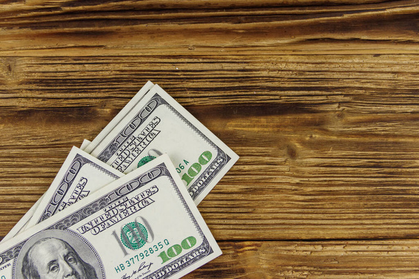 Stack of one hundred dollars bills on wooden desk - Photo, Image