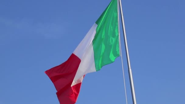 Μια ιταλική σημαία κυματίζει στο αεράκι ενάντια σε έναν όμορφο γαλάζιο ουρανό. - Πλάνα, βίντεο