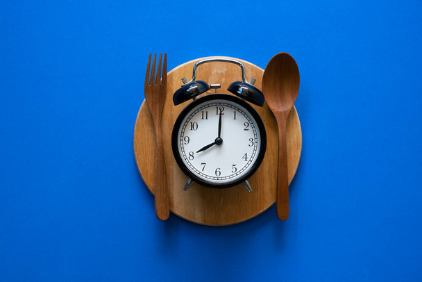 Food clock. Healthy food concept on blue background - Foto, Imagen