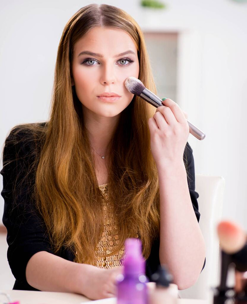 Mujer joven aplicando maquillaje preparándose para la fiesta - Foto, Imagen