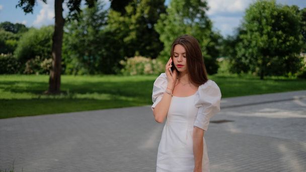 beautiful girl in a white dress walks around the city - Foto, afbeelding