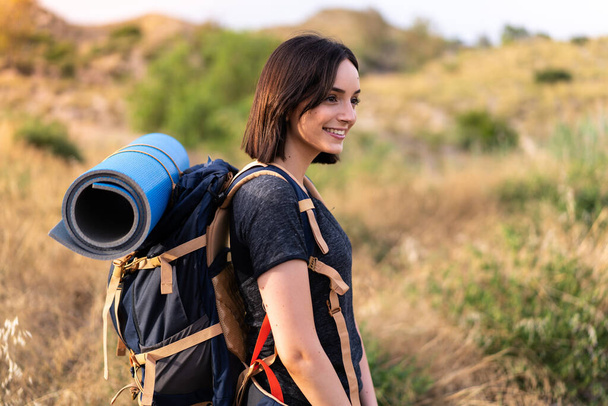 Fiatal hegymászó lány egy nagy hátizsák a szabadban - Fotó, kép