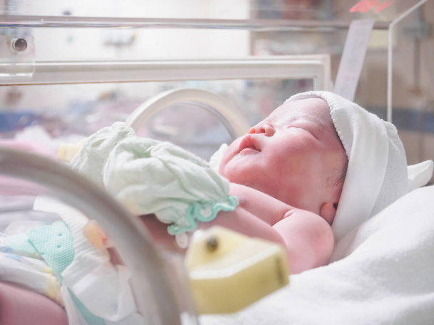 Neugeborenes Baby schläft im Brutkasten im Krankenhaus - Foto, Bild