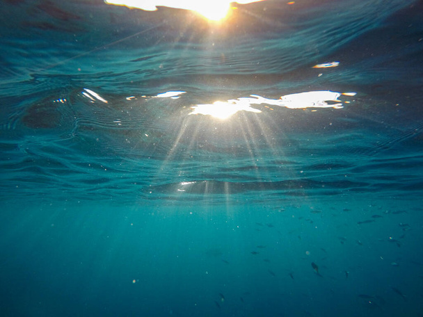 Солнечные лучи, кажется, под водой во время подводного плавания - Фото, изображение