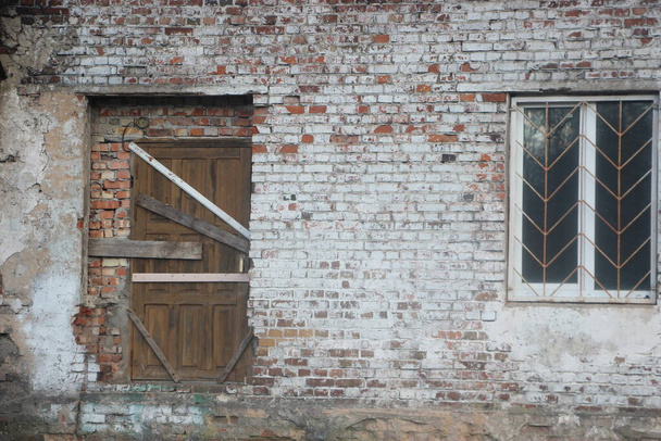 abandonada casa abandonada y edificios en una calle residencial desierta con ventanas tapiadas y paredes en descomposición - Foto, Imagen
