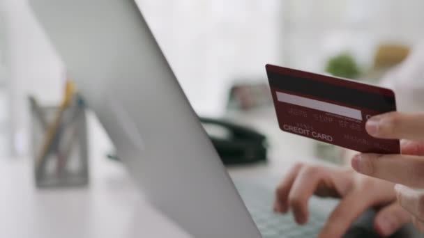 žena v ležérní oblečení držící kreditní kartu a pomocí digitálního notebooku s nákupy on-line - Záběry, video