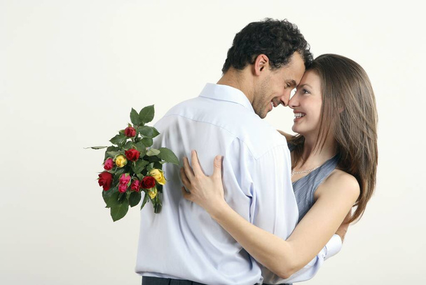 Woman hugging man for giving her a bouquet of flowers - Photo, Image