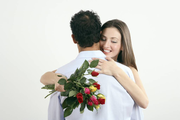Woman hugging man for giving her a bouquet of flowers - Foto, immagini