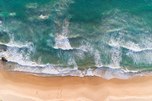 Vista aérea praia arenosa e ondas em queda na costa arenosa Mar tropical bonito na manhã verão estação imagem por visão aérea drone shot, vista de alto ângulo de cima para baixo - Foto, Imagem
