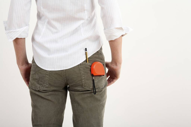 Woman with tape measure and pencil in her pants pocket - Foto, afbeelding