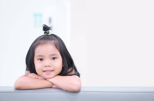 Азиатские дети милые или девочка и студент думает о новой идее и веселое веселье или улыбка на диване в детском саду или детской и детской больницы или школы с пространством на коричневый - Фото, изображение