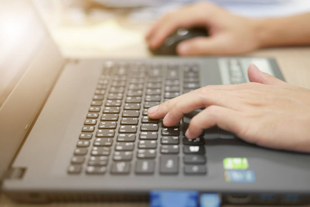 ruka podnikatele na notebooku počítače klávesnice pro práci a přehrávání na internetu nebo zkontrolovat e-mail na stole v kanceláři s obrazovkou nebo sledovat světlo - Fotografie, Obrázek