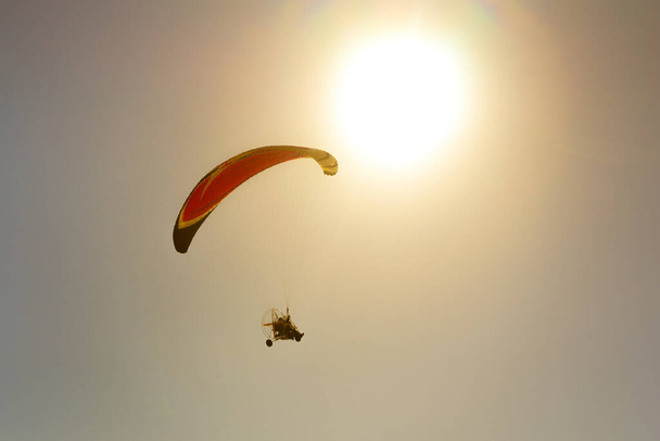 A person parasailing in the sky under the bright shining sun - Foto, Imagen