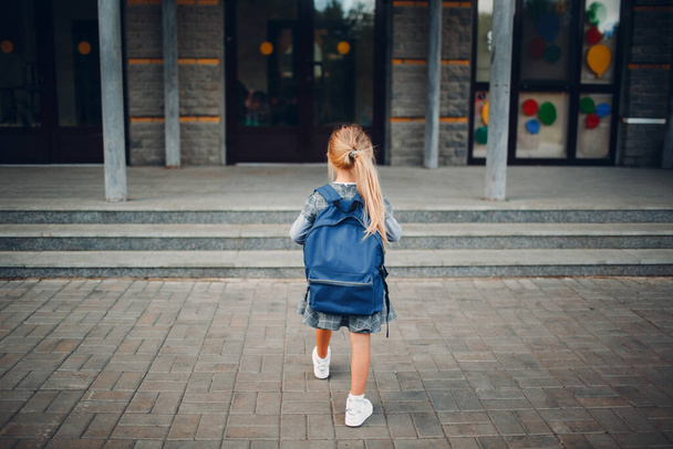 Petite fille mignonne avec sac à dos marchant de retour à l'école - Photo, image