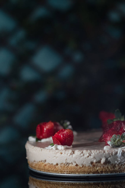 A vertical shot of a cake with strawberries on top - Photo, image