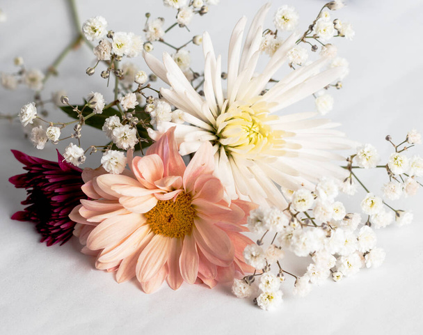A closeup of a beautiful composition with flowers on a white surface under the lights - Foto, immagini