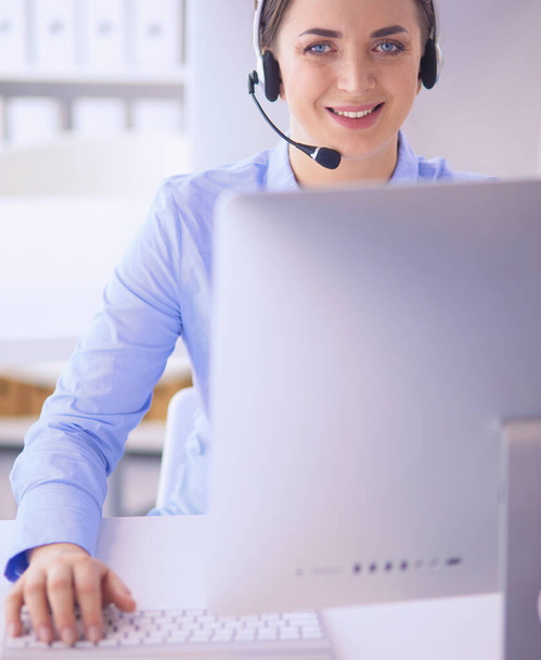 Serious pretty young woman working as support phone operator with headset in office - Foto, imagen
