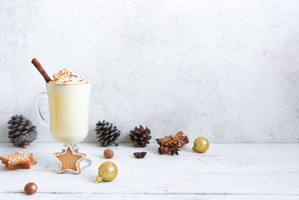 Christmas Eggnog drink with festive decor, gingerbread cookies and winter spices on white, copy space. Homemade eggnog cocktail for Christmas and winter holidays. - Фото, зображення