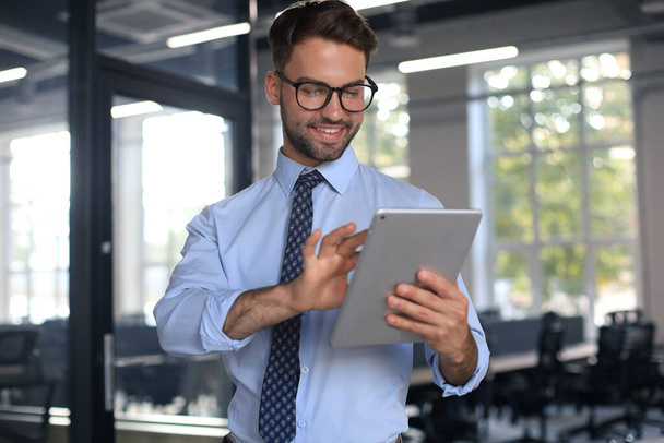 Young businessman using his tablet in the office - Foto, afbeelding