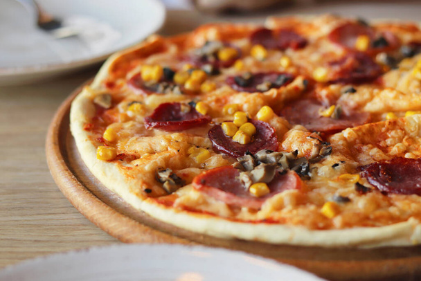 Deliciosa pizza caliente en un plato de madera. Cubertería. Copiar el espacio - concepto de comida en una cafetería, orden, servicio, apetito, publicidad - Foto, imagen