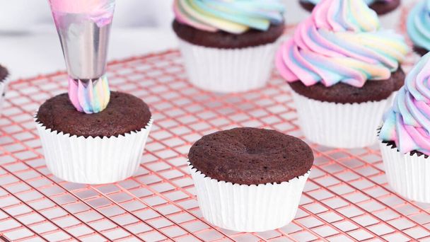 Lépésről lépésre. Cukormáz egyszarvú csokoládé cupcakes szivárvány színű vajkrém cukormáz. - Fotó, kép