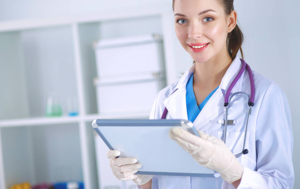 Woman doctor standing with folder at hospital - Фото, зображення