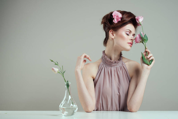 mulher romântica com flores em seu cabelo e vaso com rosa flor luz de fundo tabela - Foto, Imagem