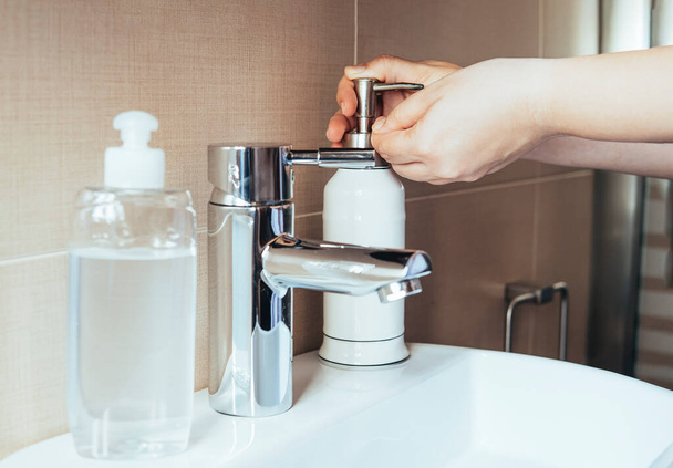 Young woman applying liquid soap to her hands.Hygiene concept, hand detail. Selective focus. - Φωτογραφία, εικόνα