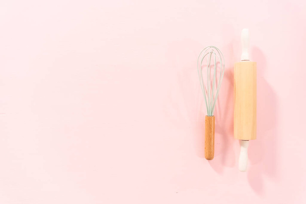 Плоский лежал. Новые силиконовые кухонные принадлежности с деревянными ручками на розовом фоне. - Фото, изображение