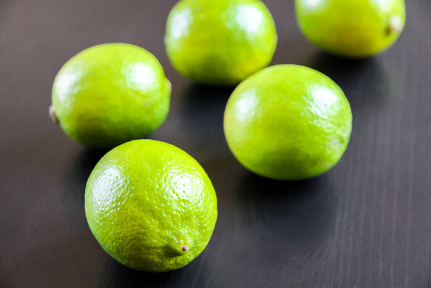 Group of fresh organic limes on a black table background - Foto, Imagem
