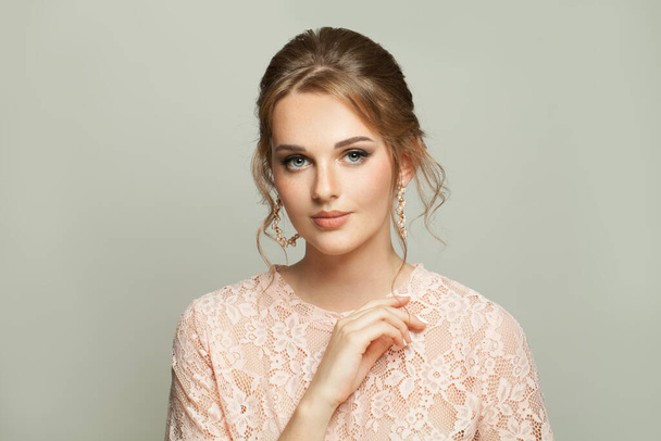 Aantrekkelijke vrouw met modieuze kapsel en pastel make-up op witte achtergrond - Foto, afbeelding