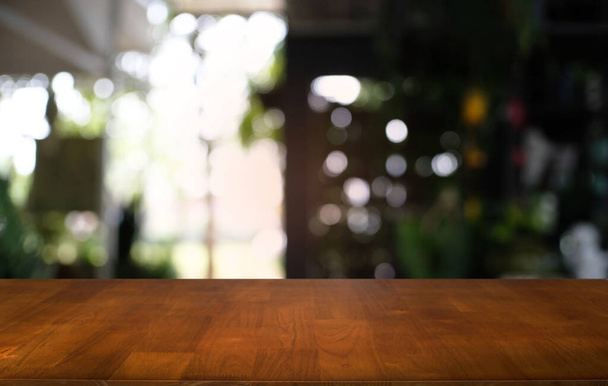 Κενό σκούρο ξύλινο τραπέζι μπροστά από αφηρημένη θολή bokeh φόντο του εστιατορίου. μπορεί να χρησιμοποιηθεί για επίδειξη ή μοντάζ τα προϊόντα σας.Mock up for space - Φωτογραφία, εικόνα