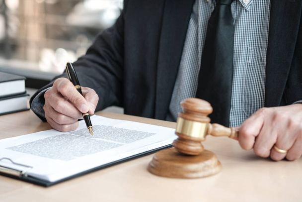 Asesoría legal presenta al cliente un contrato firmado con mazo y ley legal. concepto de justicia y abogado - Foto, imagen