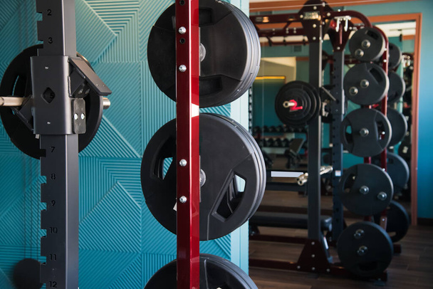 Interior moderno gimnasio con equipo. Barras, pesas, cintas de correr, equipos de cardio - Foto, imagen