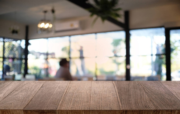 Tavolo vuoto in legno scuro di fronte astratto sfondo bokeh offuscata del ristorante. può essere utilizzato per visualizzare o montare i vostri prodotti. finto per lo spazio - Foto, immagini