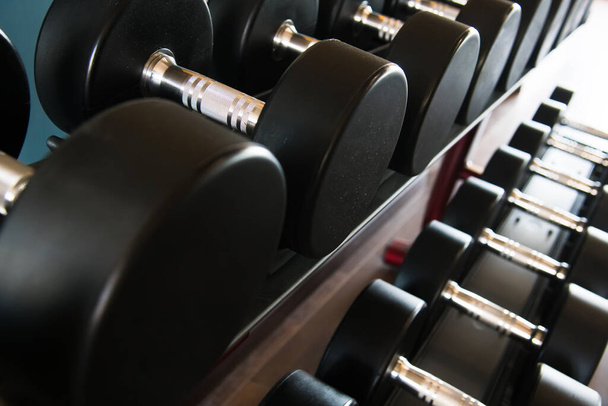 Modern gym interior with equipment. Barbells, dumbbells, treadmills, cardio equipment - Foto, imagen