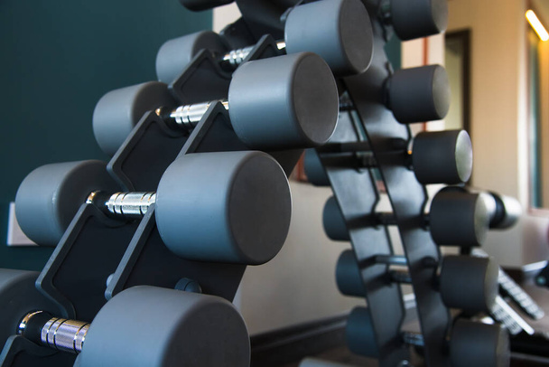 Modern gym interior with equipment. Barbells, dumbbells, treadmills, cardio equipment - Фото, изображение