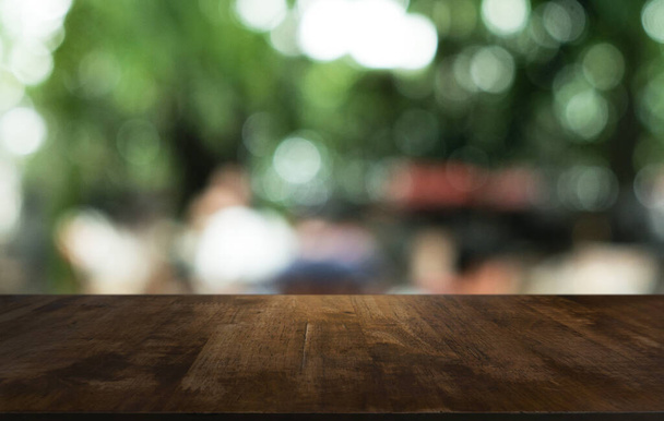 Mesa de madeira escura vazia na frente do fundo bokeh embaçado abstrato do restaurante. pode ser usado para exibir ou montar seus produtos.Preparar para o espaço  - Foto, Imagem