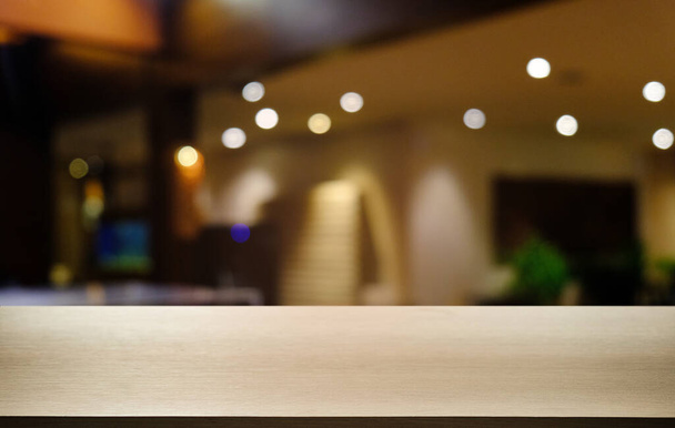 Mesa de madeira escura vazia na frente do fundo bokeh embaçado abstrato do restaurante. pode ser usado para exibir ou montar seus produtos.Preparar para o espaço  - Foto, Imagem