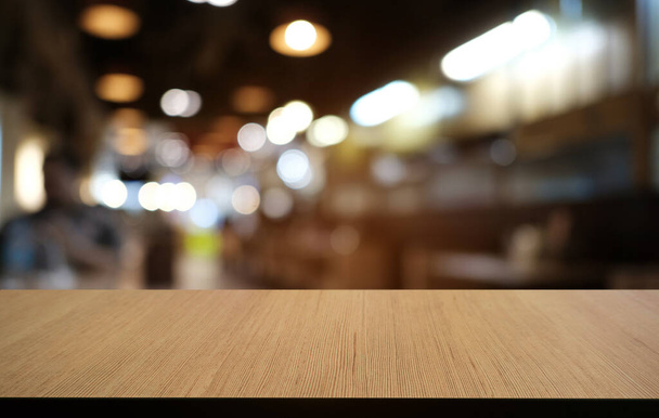 Prázdný tmavý dřevěný stůl před abstraktním rozmazaným bokeh pozadím restaurace. může být použit pro zobrazení nebo montáž vašich výrobků.Vysmívejte se pro prostor  - Fotografie, Obrázek