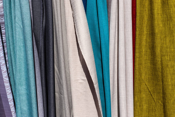 Detailed close up view on samples of cloth and fabrics in different colors found at a fabrics market. - Photo, Image