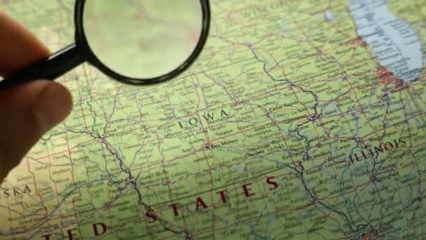 persona che guarda lo stato americano Iowa sulla mappa attraverso lente di ingrandimento - Filmati, video
