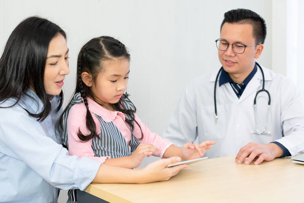 病院の開発クリニックで若い女の子と母親と話すアジア人医師。小児科医や医療の概念は - 写真・画像