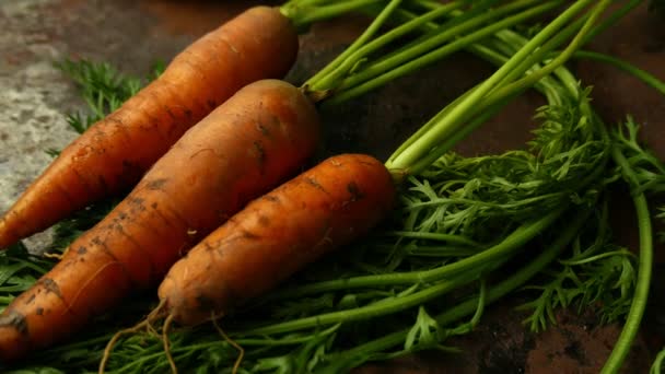 крупным планом сняты спелые морковки, лежащие на деревенском столе - Кадры, видео